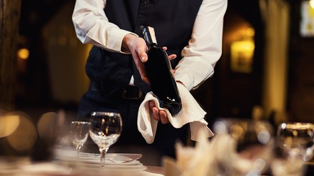 ein Kellner mit einer Flasche Wein