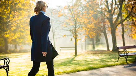 Junge Frau geht im Herbst in einem Park spazieren