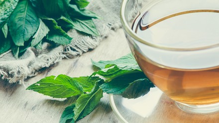 Tasse Grüner Tee mit Teeblättern