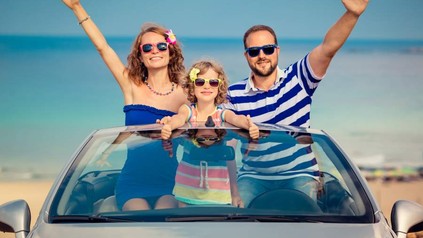 Eine Familie in einem Cabrio mit Sonnenbrillen