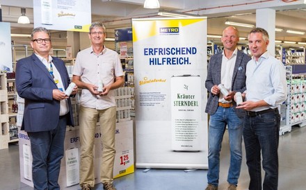 Christian Weber, Harald Jankovits, Arno Wohlfahrter und Michael Priessnitz stehen fröhlich vor einem Metro-Plakat