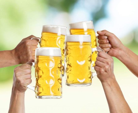 Vier Personen stoßen mit ihrem Bier an