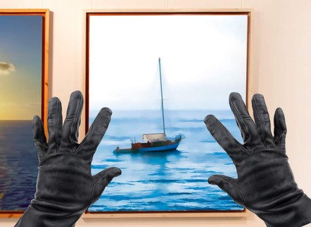 Zwei Hände, die ein Bild mit einem Schiff von der Wand stehlen