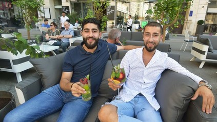 Philipp und Dominik Ercin mit Getränken auf einer Bank