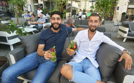 Philipp und Dominik Ercin mit Getränken auf einer Bank