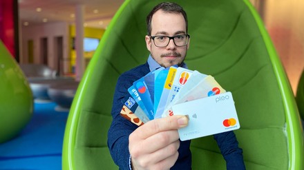 Junger Mann hält verschiedene Kreditkarten und Debitkarten in der Hand