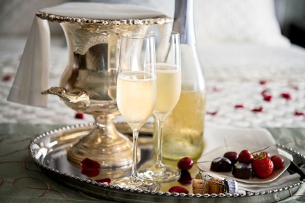 Eine Flasche Schaumwein und zwei Gläser mit Schaumwein auf einem edlen Tablet