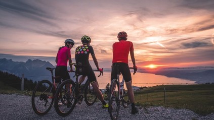 Drei Radfahrer sehen sich einen Sonnenuntergang an