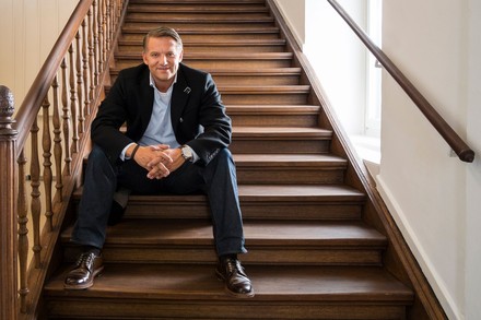 Alexander Fitz sitzt lächelnd auf einer Treppe