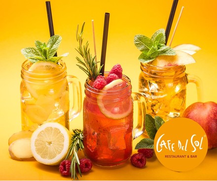 Drei bunte Getränke auf einem Tisch mit frischem Obst und dem Logo von Cafe del sol