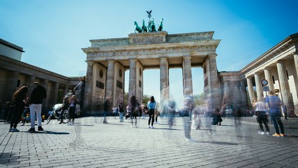 Viele Menschen laufen durch das Brandenburger Tor in Berlin
