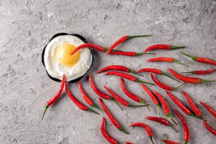 Ein Spiegelei und viele Chilischoten, die zu dem Ei hinführen