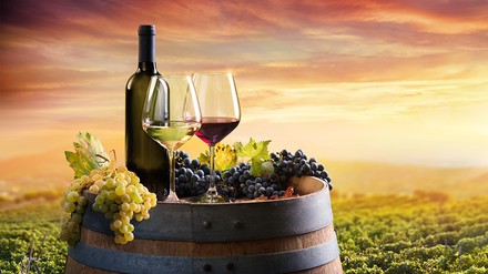 Ein Weinfass mit Weingläsern und Weintrauben