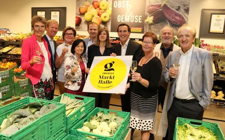 Gruppe von Menschen die das Schild mit dem Logo der Markthalle hochhalten