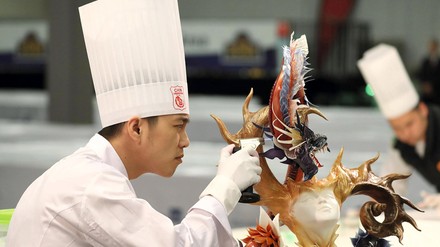 Auch Einzelaussteller und Food-Artisten nehmen an der IKA/Olympiade der Köche teil, die 2020 erstmals parallel zur INTERGASTRA stattfindet. (Foto: © VKD/ IKA/Olympiade der Köche) Asiatischer Koch oder Foodartist arbeitet konzentriert an einem Ausstellungsobjekt