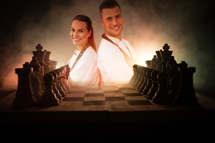 Ein Schachbrett und zwei Hotelmitarbeiter im Hintergrund