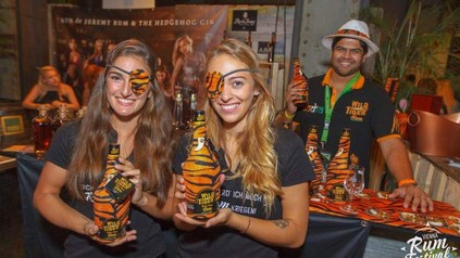Menschen auf einer Getränkemesse mit dem Getränk Tiger Wild in der Hand