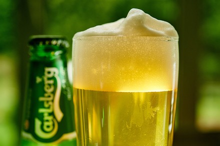 Eine Bierdose und ein Glas voller Carlsberg Bier