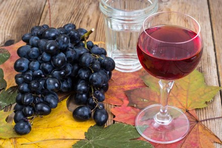 Ein Glas Wein und Weintrauben