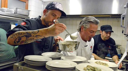 Mann in Küche schenkt Essen aus
