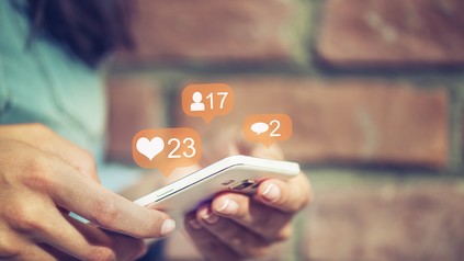Person checkt Kommentare und Likes auf dem Smartphone
