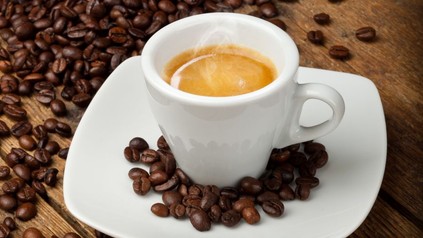 Espresso in einer Tasse, Kaffeebohnen rundherum