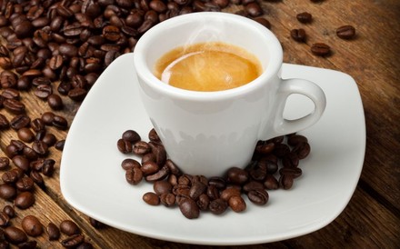 Espresso in einer Tasse, Kaffeebohnen rundherum