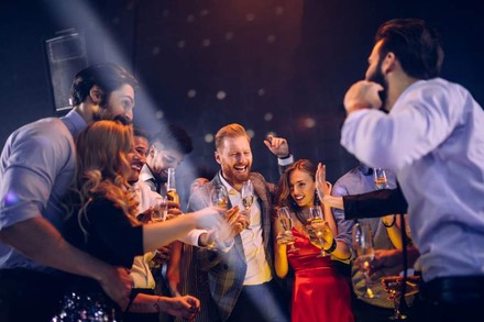 Junge fröhliche Menschen auf einer Ballermann-Party, die tanzen und Bier trinken.