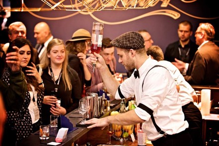 Ein Barkeeper mixt vor vielen Zuschauern einen Cocktail im Rahmen des Bar Convent Berlin.
