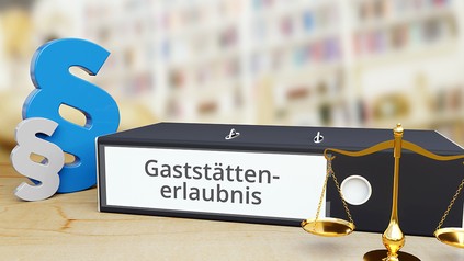 Ordner auf Schreibtisch mit Beschriftung neben Paragraf und Waage