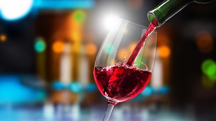 Ein Glas Wein wird eingeschenkt