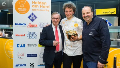 Marianus von Hörsten mit Johann Lafer und einem weiteren Würdenträger hält einen goldenen Topf in der Hand