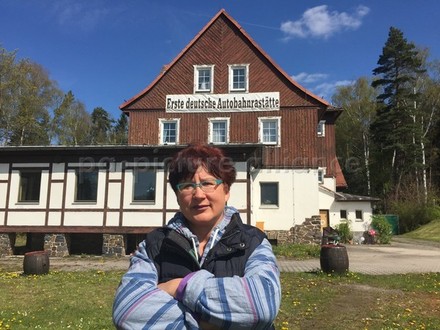 Frau vor erster deutschen Autobahnraststätte