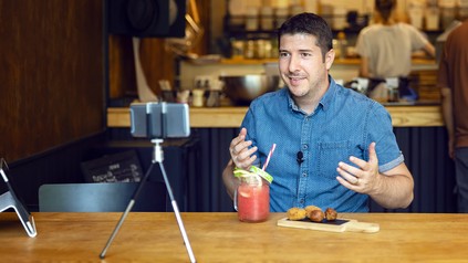 Mann dreht mit Smartphone Video in Restaurant