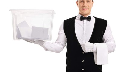 Ein Gastronomiemitarbeiter mit einer Wahlurne in der Hand