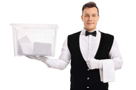 Ein Gastronomiemitarbeiter mit einer Wahlurne in der Hand