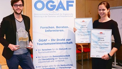 MCI-Absolventen Lena Hüttl (rechts) und Moritz Busch nehmen ihre Auszeichnungen sowie die Trophäe für das MCI als beste Tourismus-Ausbildungsstätte Österreichs in Empfang