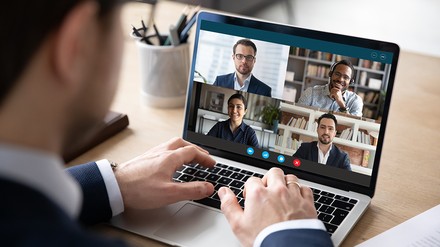 Nahaufnahme eines Mannes, der am Laptop setzt und eine virtuelle Konferenz hält