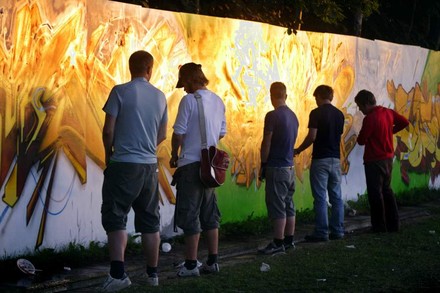 Mehrere Männer pinkeln an eine Wand