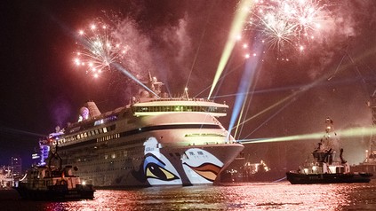 Das Kreuzfahrtschiff AIDA aura unter einem nächtlichen Feuerwerk im Hafen