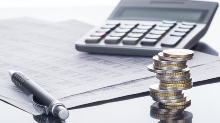 Geld, Stift, Block und Taschenrechner