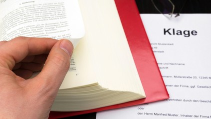 Klageschrift und Gesetzbuch
