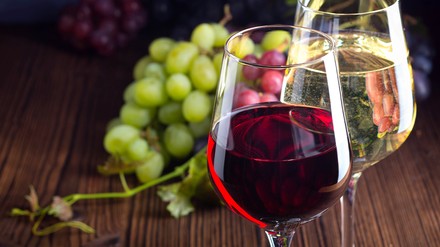 Zwei Weingläser mit Weiß- und Rotwein gefüllt