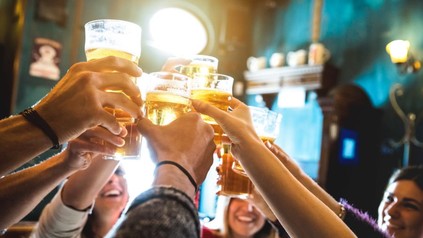 Gruppe von Freunden stößt in einer Bar mit Bier an