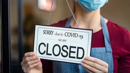 Gastronom hängt ein Geschlossen-Schild an die Restauranttür