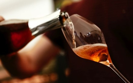 Ein Glas Rosé-Sekt wird eingeschenkt