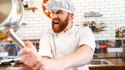 Ein wütender Koch mit einer Bratpfanne in der Hand