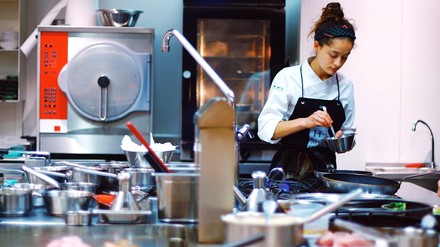 Eine Profiköchin in einer Großküche