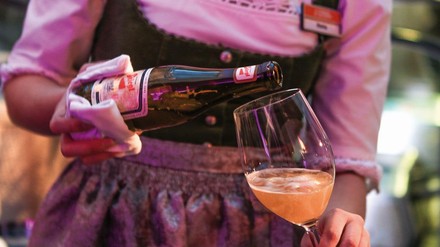 kellnerin schenkt ein Glas Bier aus der Flasche ein