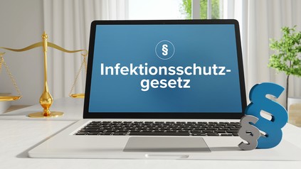 Laptop im Büro mit Begriff auf dem Monitor, Paragraf und Waage
